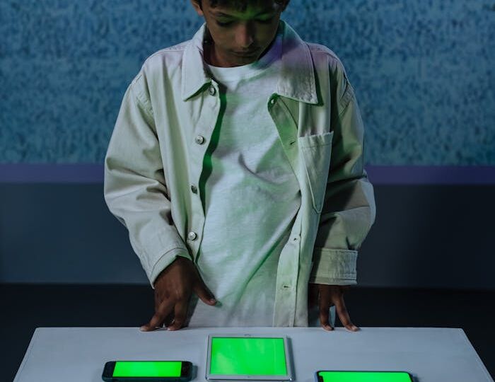 Young boy in studio with green screen gadgets on a table indoors.